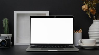 Siyah masadaki boş ekran laptopuyla son moda fotoğrafçı işyeri görüntüsü. 