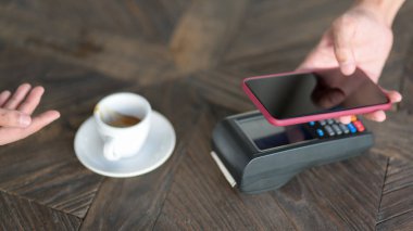 Kahve ısmarlamak için akıllı telefon kullanan erkek müşterinin görüntüsü, kahve dükkanında cep telefonu ödemesi. 