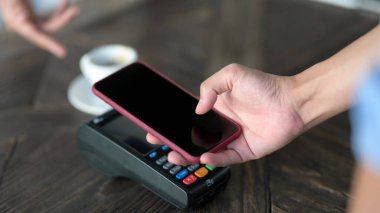 Kahve ısmarlamak için akıllı telefon kullanan erkek müşterinin yakın görüntüsü, kahve dükkanında cep telefonu ödemesi 
