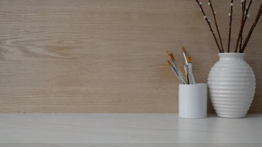 Fotokopi alanı, fırça ve seramik vazo ile modern kırsal duvarlı mermer masa üzerindeki basit işyeri manzarasını kapat