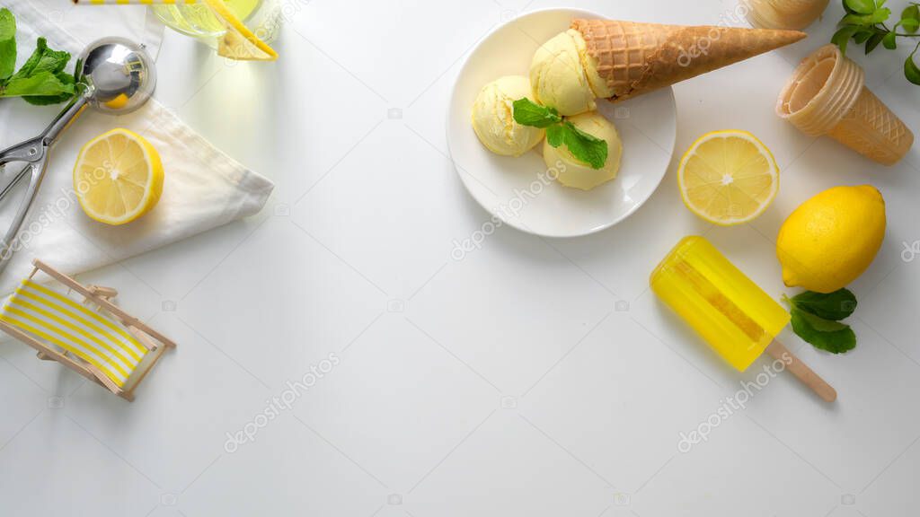 Overhead shot of summer dessert, lemon ice-cream cone on white desk with lemon ice-cream on plate, copy space and decorations
