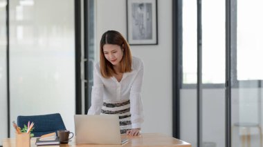 İş kadınının rahat ofis odasında çalışırken dizüstü bilgisayara baktığı görüntüyü kapat.