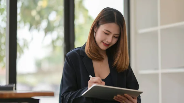 Close up view of businesswoman drawing on digital tablet while sitting in modern office room