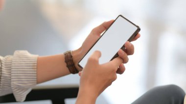 Basit ofis odasındaki kanepede otururken akıllı telefondan mesajlaşan işadamlarının görüntüsünü kapat
