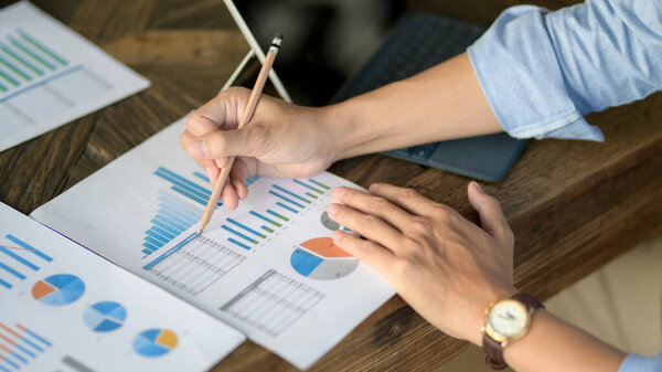 Обрезанный снимок бизнесмена, фокусирующегося на работе с бизнес-картами и цифровыми планшетами на деревянном столе
 