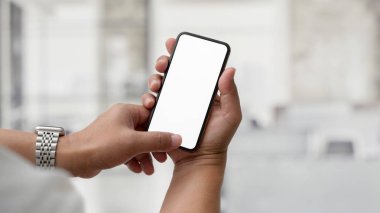 Cam bölme ofisinde dikilirken boş ekran akıllı telefonuna dokunan işadamının görüntüsünü kapat