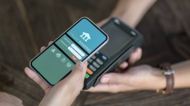 Çevrimiçi bankacılık uygulaması tarafından çevrimiçi ödeme için akıllı telefon kullanan erkek müşterinin görüntüsünü kapat 