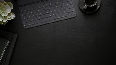 Ofis malzemeleri, kahve fincanı, dekorasyonlar ve siyah masa üzerindeki fotokopi alanı ile modern iş yerinin genel görüntüsü.  