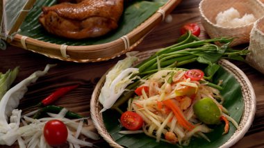 Kırpılmış Somtum veya papaya salatası, Tayland geleneksel tavuk ızgaralı ve hasır üzerine yapışkan pirinç.