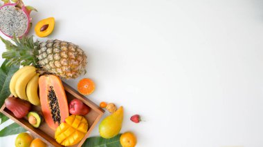 Egzotik meyveler, yaz meyveleri, sandıktaki tropikal meyveler ve beyaz arka plandaki kopyalama alanının en üst görünümü