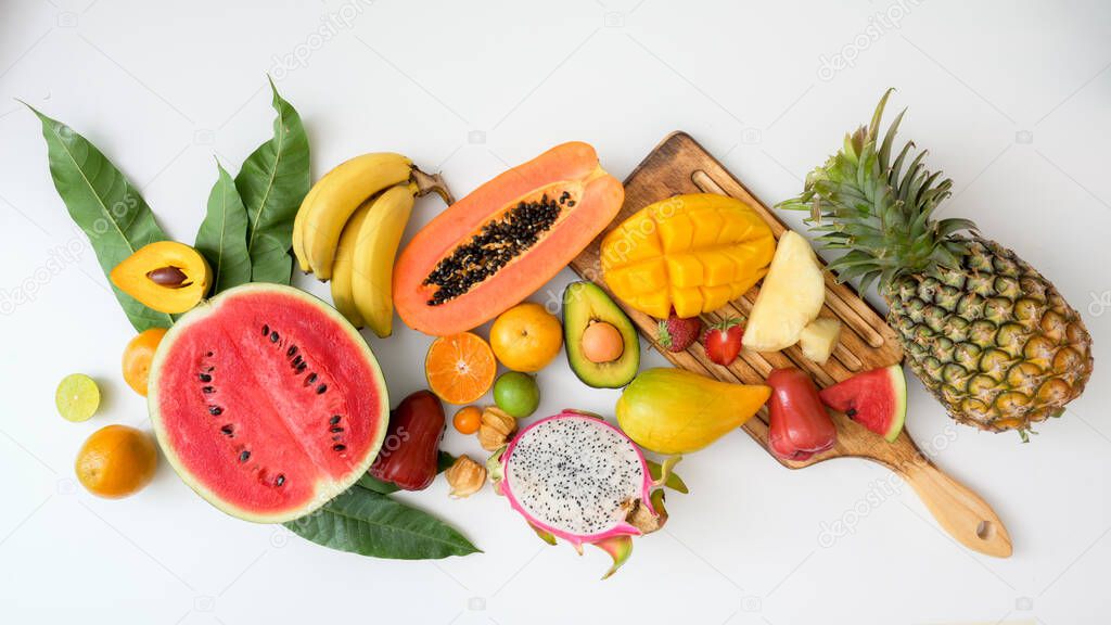 Top view of assortment of exotic fruits, summer fruits, tropical fruits and leaves on white background