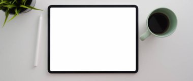 Boş ekran tableti, dekorasyon ve kahve fincanı beyaz masada. 