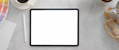 Model tablet, tasarım malzemeleri ve mermer masanın üzerinde kahve fincanı olan minimal tasarımcı çalışma alanı. 