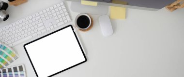 Model tablet, bilgisayar aygıtı, tasarımcı gereçleri ve beyaz masa üzerindeki kopyalama alanı ile şık çalışma alanının genel görüntüsü