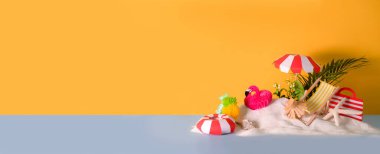 Plaj şemsiyeli, sandalyeli, plaj aksesuarlı ve sarı arka planda kumlu minimal yaz konsepti.