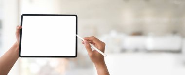 Bulanık ofis arka planında Stylus ile boş ekran tableti kullanan bir adamın kırpılmış görüntüsü.
