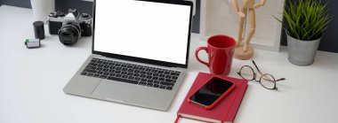 Ofis masasının çekimleri sahte dizüstü bilgisayar, akıllı telefon ve ofis malzemeleri beyaz masa arkasında. 