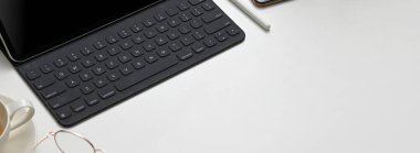 Tablet ve ofis malzemeleriyle dolu en küçük ofis odasının beyaz masa üzerinde fotokopi alanı. 