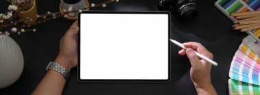 Model tablet üzerinde erkek tasarımcı çiziminin üst görüntüsü. Stylus kalem ile karanlık modern çalışma tablosunda diğer malzemeler ve dekorasyonlarla birlikte.