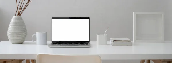 モックアップノートパソコン マグカップ 電源と現代の自宅のオフィスで椅子で装飾と最小限の作業台のビューを閉じます — ストック写真