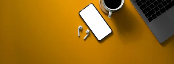 空白の画面スマートフォン デジタルデバイス コーヒーカップと黄色の机の上にコピースペースで創造的な作業テーブルのオーバーヘッドショット — ストック写真