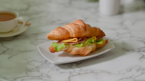 在大理石桌子上放有羊角三明治火腿和奶酪的一盘早餐餐的近景 — 图库照片