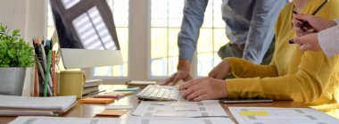 UI geliştirici ekibinin bilgisayar aygıtı ve evrak işleriyle çalışma alanındaki projelerine danışmanlık yapmasının yan görünümü