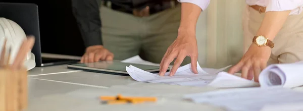 stock image Cropped shot of two engineers consulting on their project with mock-up tablet and paperwork on white table in meeting room 