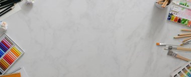 Fotokopi alanı, resim araçları ve mermer masadaki kırtasiye malzemesi ile modern çalışma alanının üst görünümü 