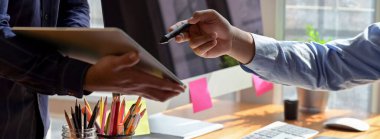 Ofis odasında dijital tabletle projelerine danışmanlık yapan iş adamlarının kırpılmış görüntüleri 