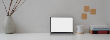 Modern ofis masasının görünümünü laptopla, fincanla, dekorasyonla ve beyaz masadaki boşluğu kopyalayarak kapat 