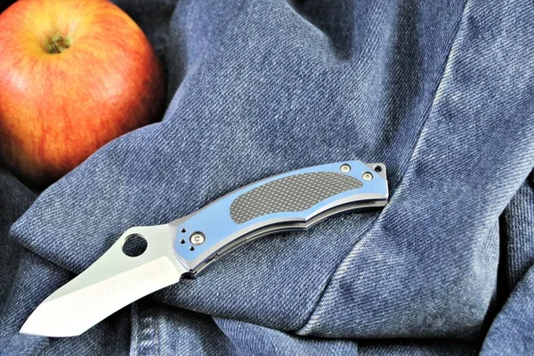 Folding knife apple organic vitamins gourmet healthy product denim background