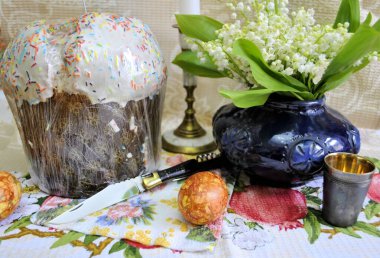 Katlanmış bıçak paslanmaz çelik bıçak siyah saplı, tirbuşonlu beyaz zambaklı vadi çiçekleri yumurtalı Paskalya kutlaması arka planı.