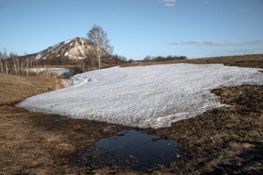 Bashkortostan 'ın bahar manzarası. Issız bir dağ, bir shihan, sade, ender ağaçların etrafında ve derelerde kar..