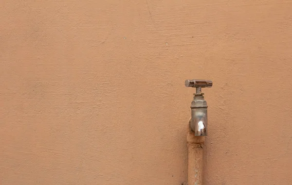 Grifo de agua de acero inoxidable unido a la pared en el exterior del edificio . —  Fotos de Stock
