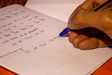 Not defterine not alan biri. Bir çalışma kağıdına fotoğraf ipuçlarını not etmek.