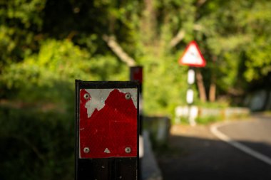 Yolun kenarını gösteren korkuluk duvarındaki kırmızı yansıtıcılar..