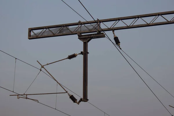 Widok napowietrznych linii elektrycznych używanych w lokomotywach kolejowych. Biegun podtrzymujący linie energetyczne wykorzystywane przez elektryczne silniki pociągów. — Zdjęcie stockowe
