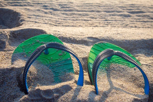 Vista de chinelos enterrados na areia da praia — Fotografia de Stock