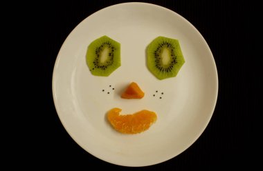 Kivi, papaya ve portakaldan yapılmış gülen surat..
