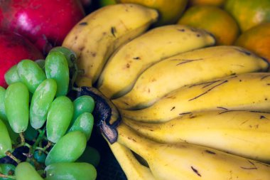 Yeşil üzümler, muz, portakal ve nar meyveleri bir arada. Meyve kavramı için kullan.