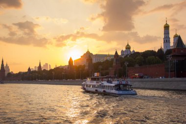 Gün batımında Moskova Nehri boyunca bir nehir otobüsü Kremlin 'in arka planına karşı yüzer. Nehrin manzarası.