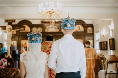 Bir kadın ve bir erkek kilisede düğün merasimi düzenliyor. Düğün taçlarında, arkadan görünüşü, karı ve koca.