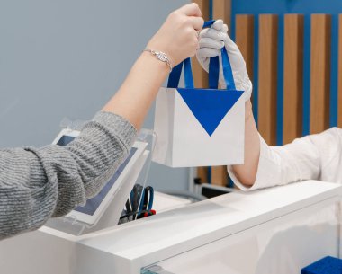 Satıcı ödemeden sonra dükkandaki alıcıya mavi paketli beyaz bir kart verir.