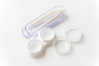 Kontakt lensler, kontakt lensler ve cımbızlar için hafif bir arka plana karşı bir konteynırda solüsyondadır. Görüşü düzeltmek için kişi lensleri.