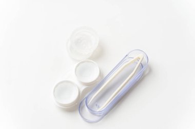 Kontakt lensler, kontakt lensler ve cımbızlar için hafif bir arka plana karşı bir konteynırda solüsyondadır. Görüşü düzeltmek için kişi lensleri.