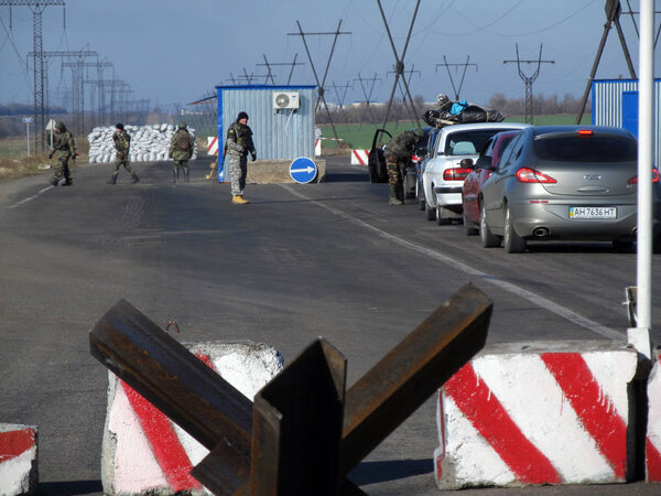 KURAKHOVO, UKRAINE - OCTOBER, 2014: Ukrainian border guards check vehicles on the security checkpoint