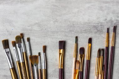 Boya fırçaları gri bir arkaplan üzerine dağılmış, araçlar çizim üst görünüm, kopyalama alanı, yakın çekim