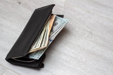 İçinde avro ve dolar olan unutulmuş cüzdan odanın zemininde yatıyor. Kopya alanı ile yakın çekim. Alışveriş ve tüketim kavramı