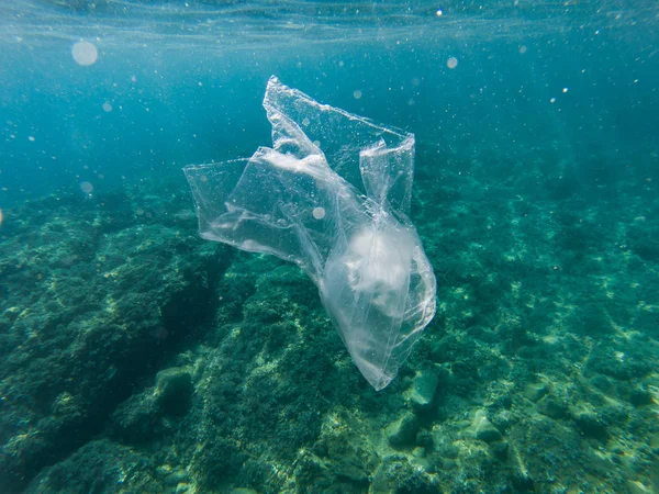 Plastic bag floating in the mediterranean sea, Catalonia, Spain. Water is polluted by single use plastics. Reuse, reduce, recycle